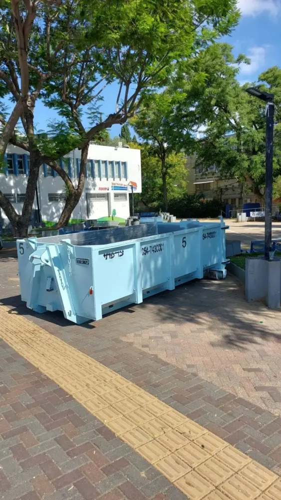 מכולות פסולת מוצבות ליד בניין ציבורי